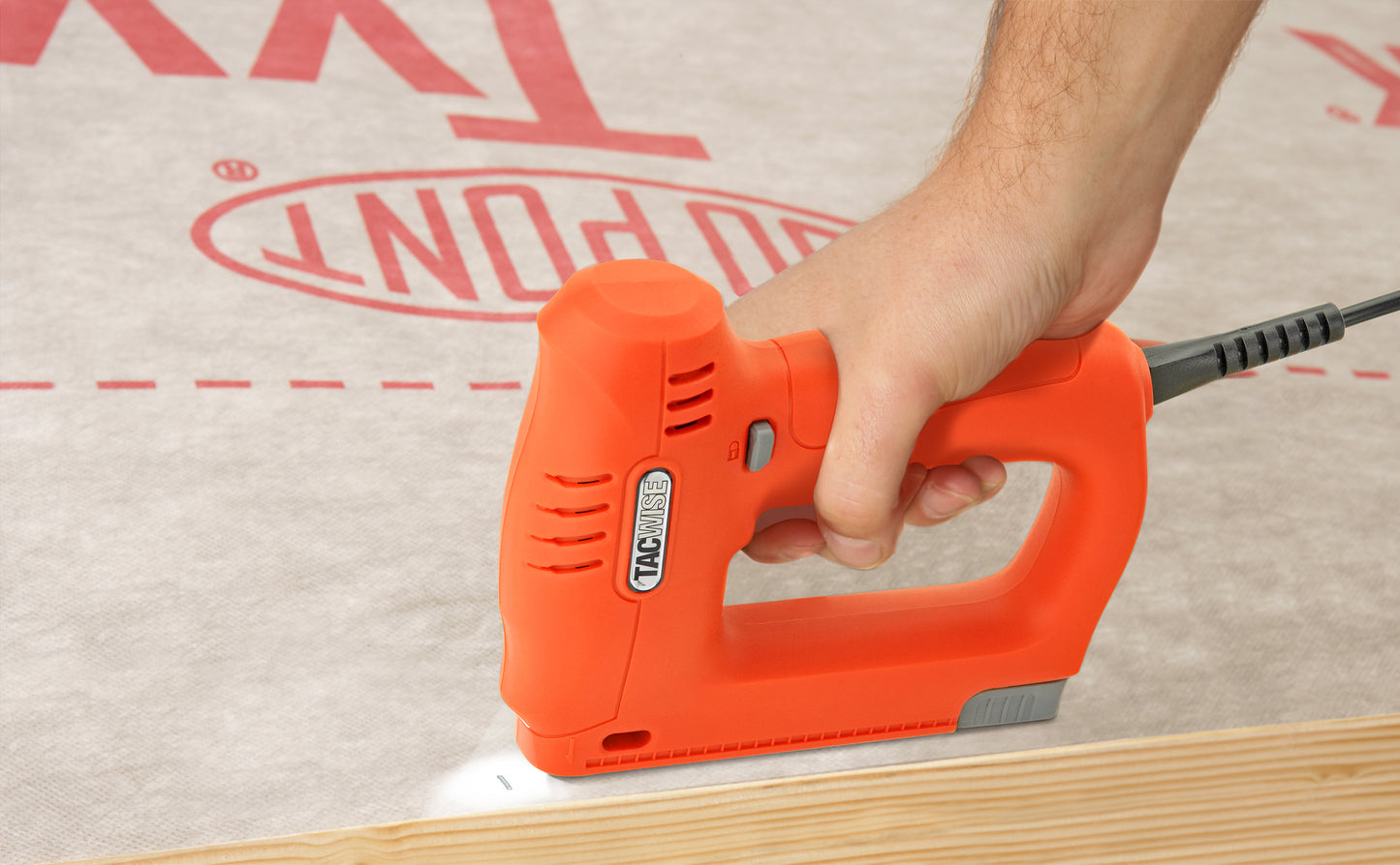 Male construction worker using the electric Tacwise 18 gauge brad nailer to fix membrane onto timber frame.